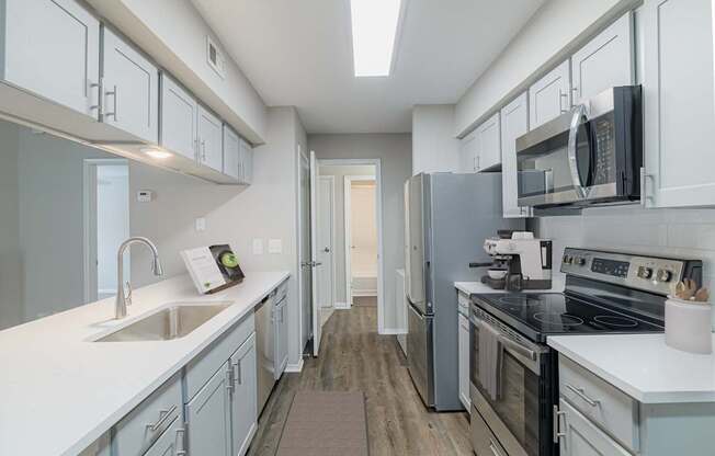 A kitchen with white cabinets and a black stove top oven.