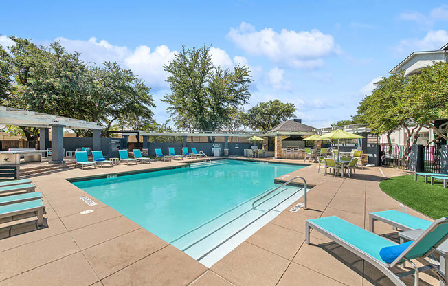 Community Swimming Pool with Pool Furniture at Allure North Dallas Apartments in Dallas, TX.