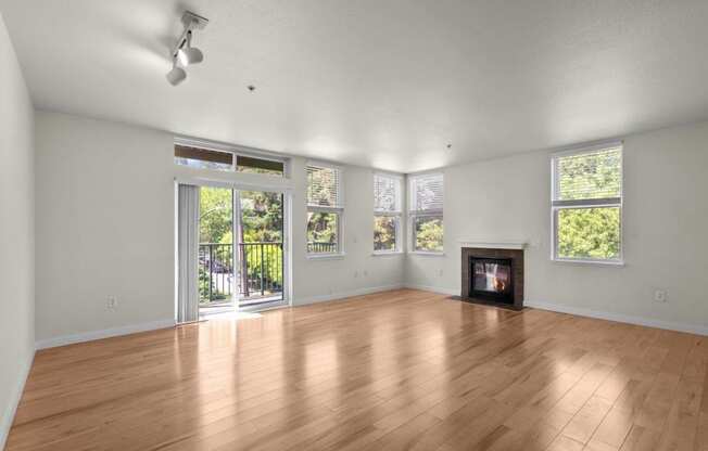 an empty living room with a wood floor and a fireplace