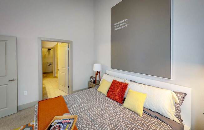 A bedroom with a bed, a chair, and a lamp.