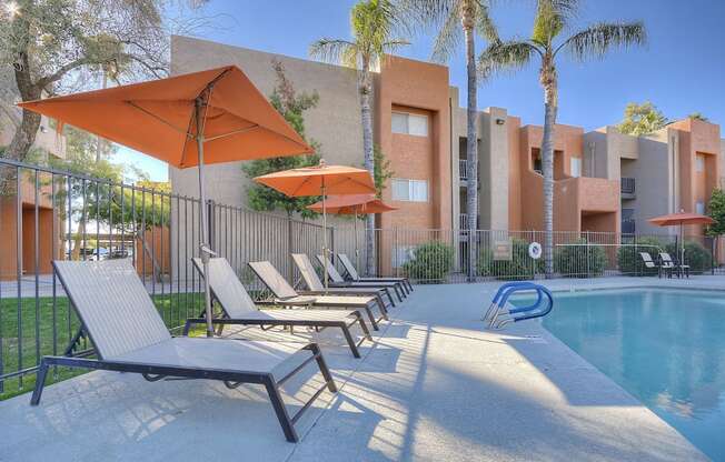 A poolside area with sun loungers and umbrellas.