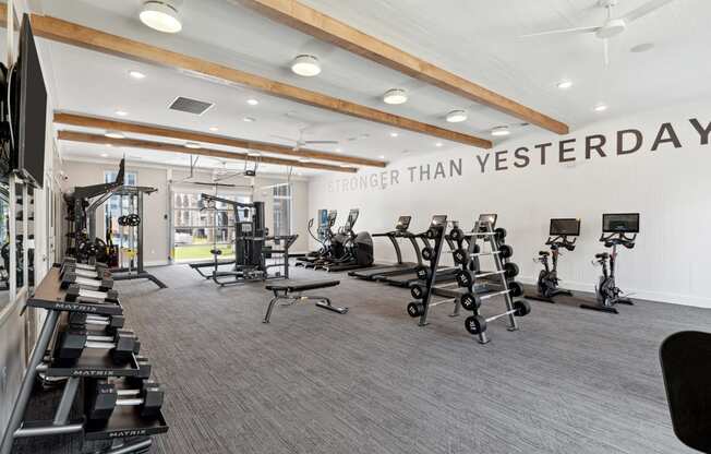 the gym with weights and treadmills at the belgard apartments