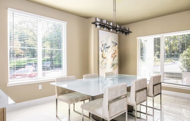 A dining room with a glass table and chairs.