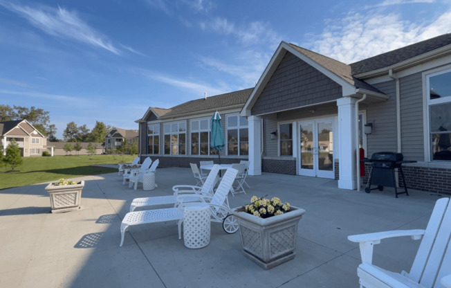 a patio with chairs and tables in front of a building