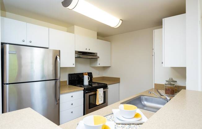 a kitchen with stainless steel appliances and white cabinets