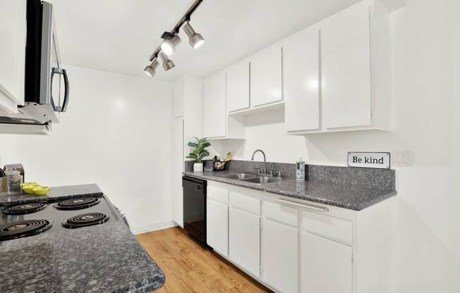 a kitchen with white cabinets and granite counter tops at Casa Del Amo Apartments, Torrance, 90505