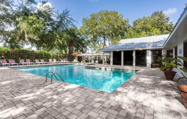A pool surrounded by trees and a building.