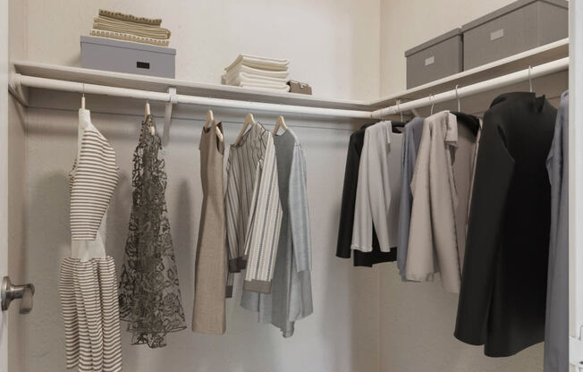 an image of a closet with clothes hanging on a rack