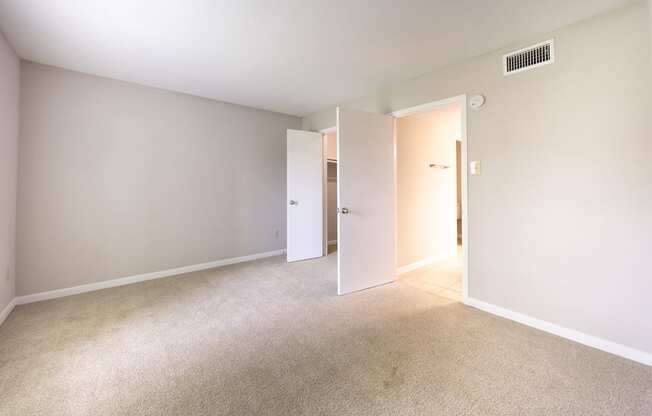 A room with a carpeted floor and two white doors.