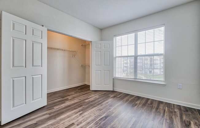 a bedroom with a closet and a large window