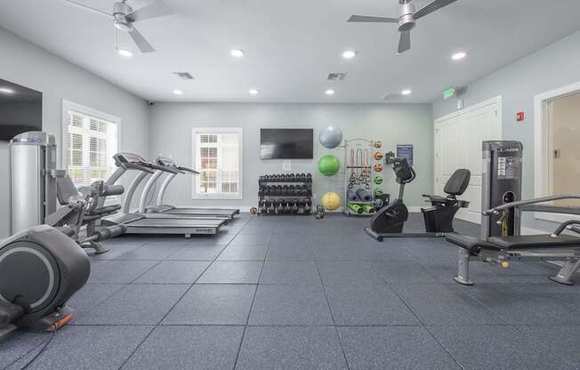 A spacious gym with treadmills, elliptical machines, and other exercise equipment.at Spring Creek Apartments, Crestview Florida