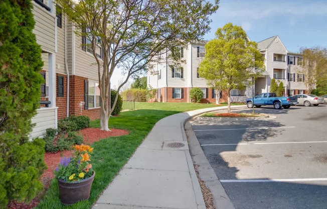 A view of a street with apartment buildings and cars.