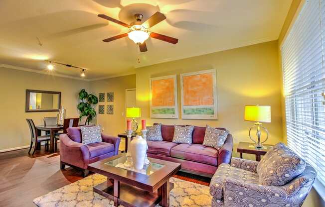 a living room with furniture and a ceiling fan