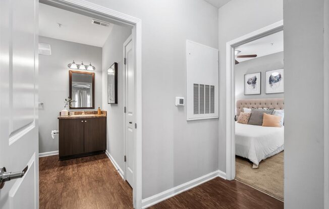 A bedroom with a white bed and a brown dresser.