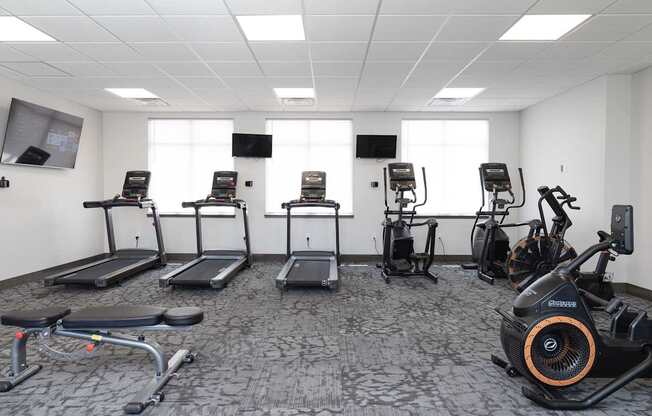 A gym with treadmills, exercise bikes, and elliptical machines.