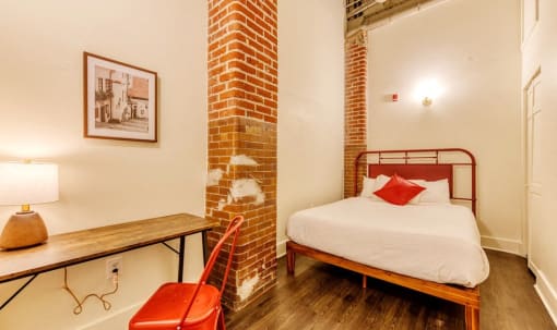 a bedroom with a bed and a desk and a chair