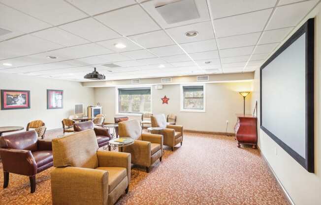 a waiting room filled with chairs and a projector screen in a hospital