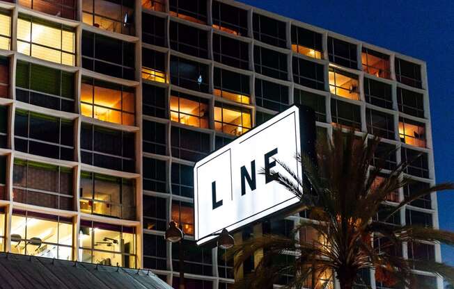 a large white sign with the word line on it in front of a large building at night