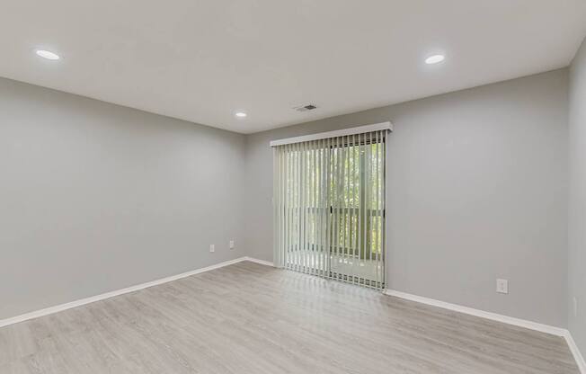 A room with a sliding glass door and light grey walls.