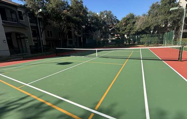 a pickleball and tennis court surrounded by trees at River Stone Ranch in Austin, Texas.