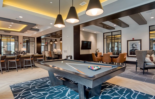 a billiards table in a clubhouse with tables and chairs at Aura Stonebridge, Richmond Virginia