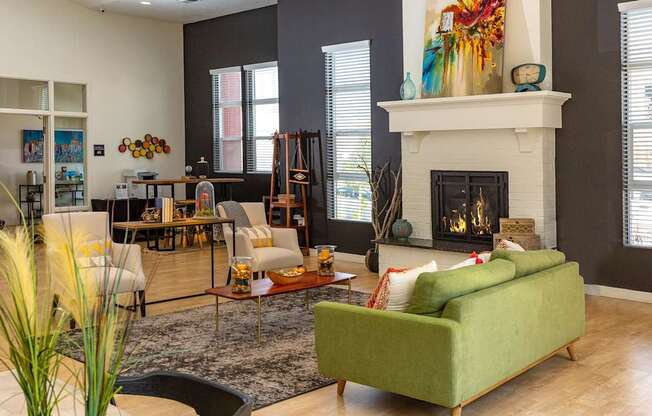 A living room with a green couch and a fireplace.