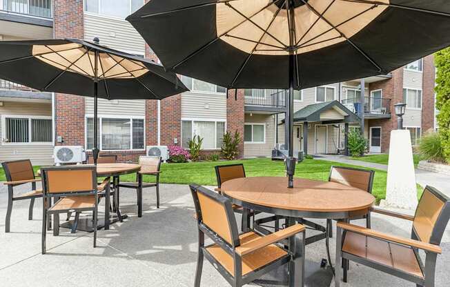 A patio with a table and chairs under an umbrella.