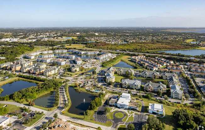 A bird's eye view of a residential area with a lake and a road.
