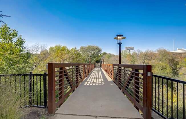 a bridge over a river with trees and a blue sky