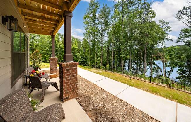 a covered porch with a view of a lake and trees