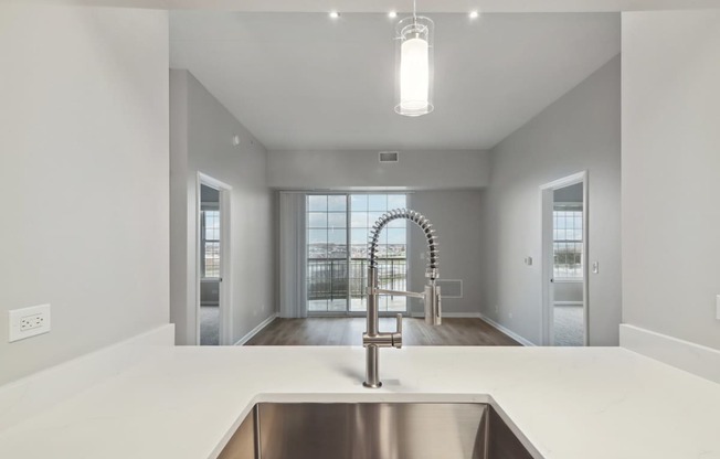 A modern kitchen with a stainless steel sink and a large window.
