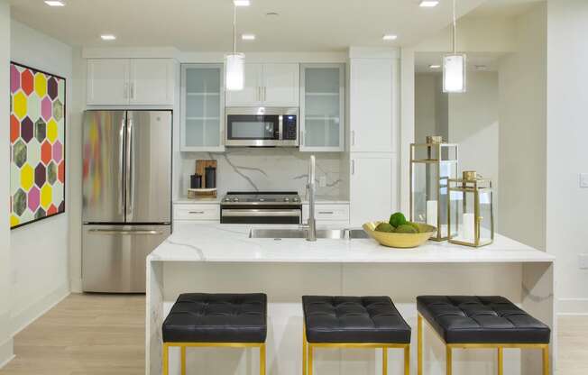 Apartments for Rent in Woodland Hills, CA - The Q Variel - Modern Kitchen with Custom Cabinets, Quartz Countertops and Backsplash, Luxury Vinyl Plank Flooring, Stainless Steel Appliances, and Large Kitchen Island