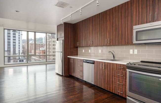 A kitchen with wooden cabinets and a stainless steel oven.