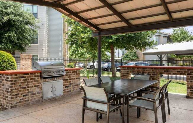 A patio with a table and chairs under a roof.