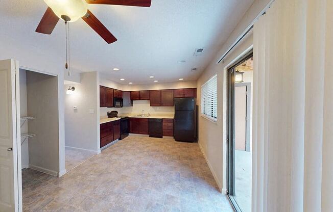 a kitchen and a living room with a ceiling fan