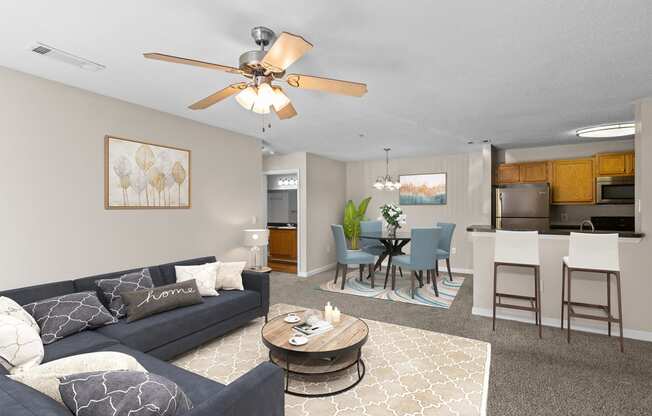 a living room with a couch and a coffee table and a dining room and kitchen
