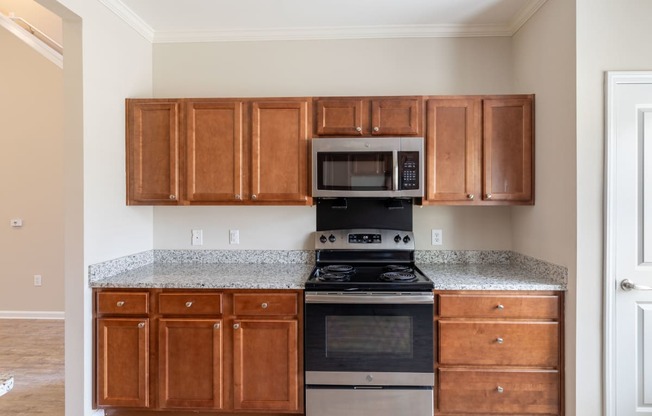 a kitchen with wood cabinets and black appliances and granite counter tops