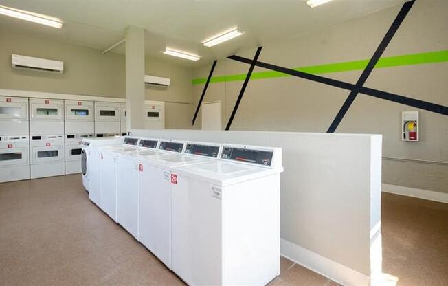 a row of washers and dryers in a room