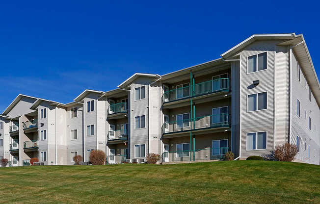 A large apartment complex with multiple balconies and green railings.