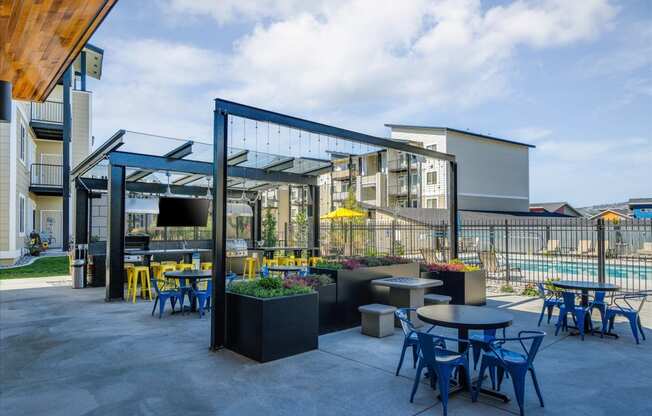 a patio with tables and chairs and a building in the background