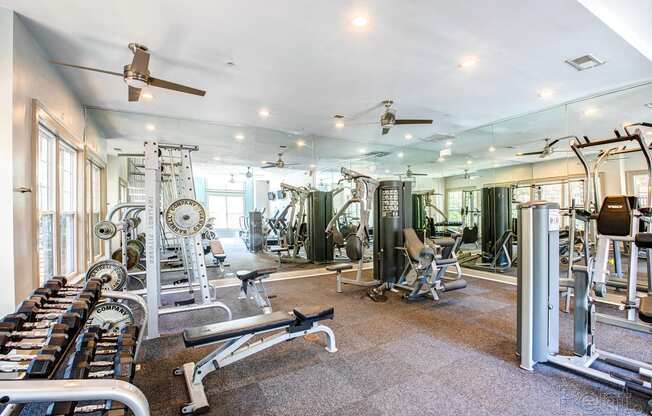 a gym with cardio machines and weights on a tile floor
