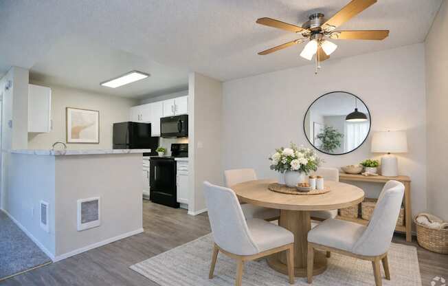 A dining room with a round table and chairs.