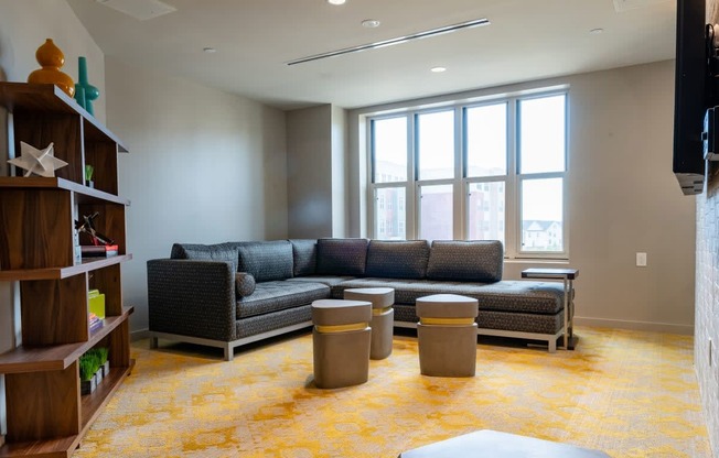 a living room with couches and tables in front of a window