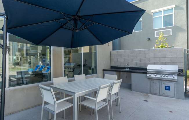 a patio with a table and chairs and a grill at Loma Villas Apartments, San Bernardino California