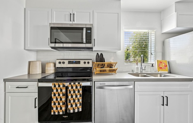 a modern kitchen with white cabinets and stainless steel appliances