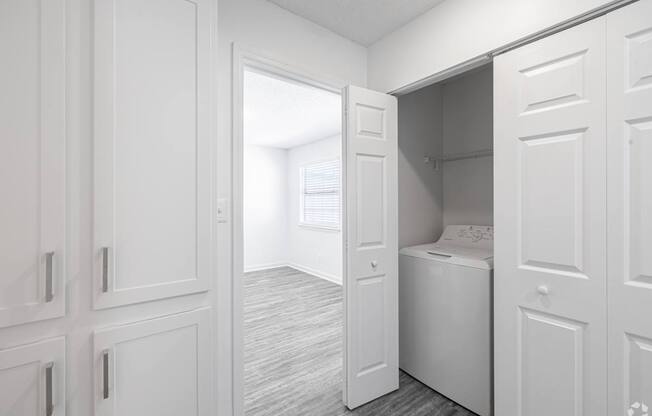 A white laundry room with a washer and dryer.