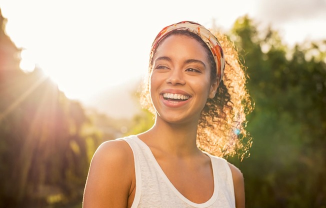 a woman smiling with the sun shining on her face