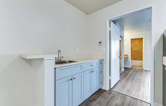 an empty kitchen with blue cabinets and a sink