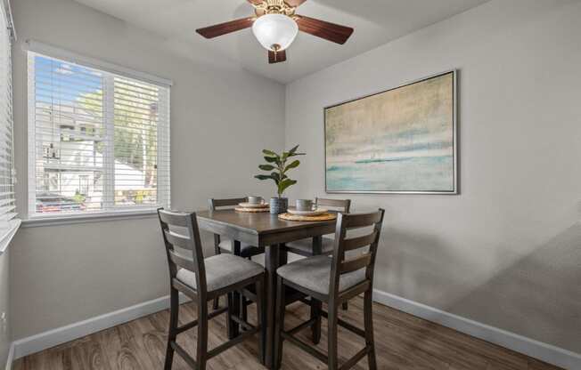 a dining room with a table and chairs and a ceiling fan