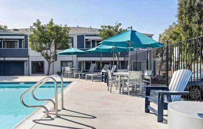 A poolside area with chairs and a table.